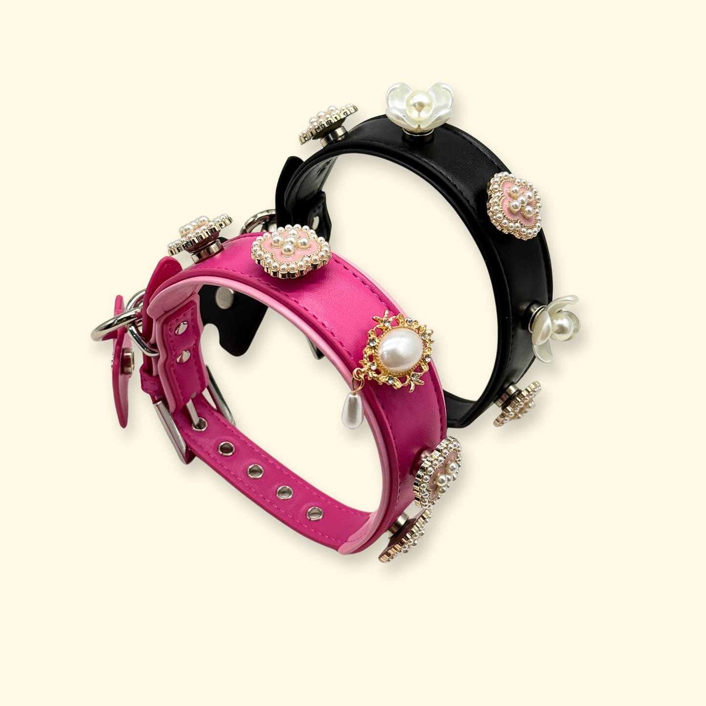 Two adjustable dog collars in pink and black leather with interchangeable pearl and floral charm decorations