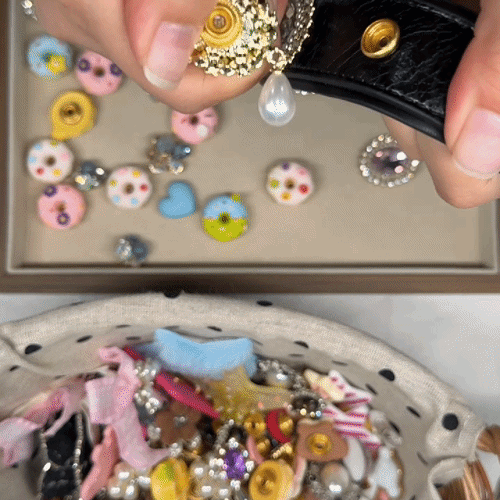 Hands attaching interchangeable charms onto a black customizable dog collar