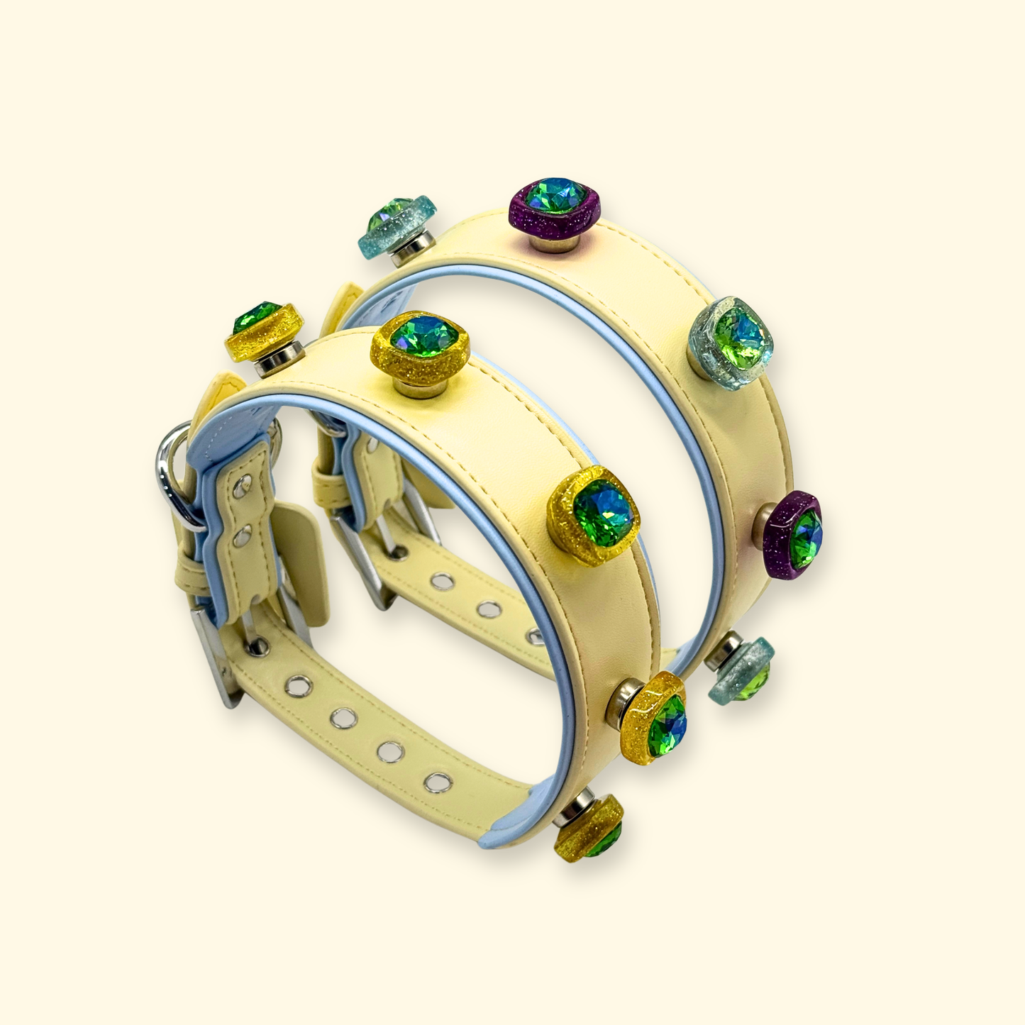 Stacked adjustable dog collars in neutral tones with interchangeable crystal snap-on charms for pet customization