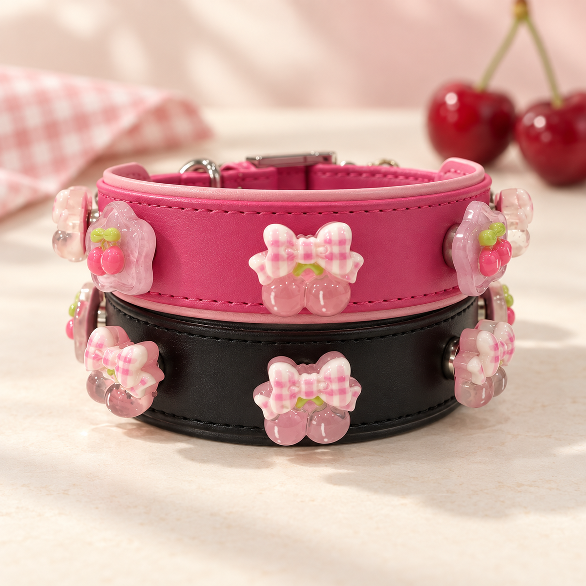 Cherry dog collar charms with playful pink fruit designs styled on pink and black PETIRIA collars