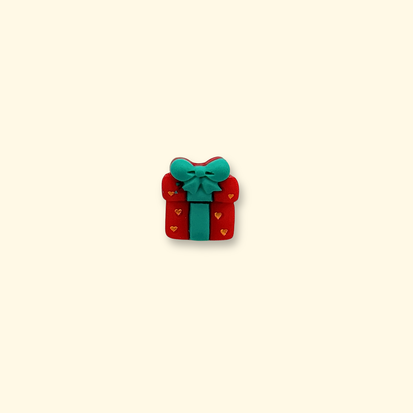 A festive red Christmas gift charm with a teal ribbon, designed for pet collars, perfect for the holiday season.