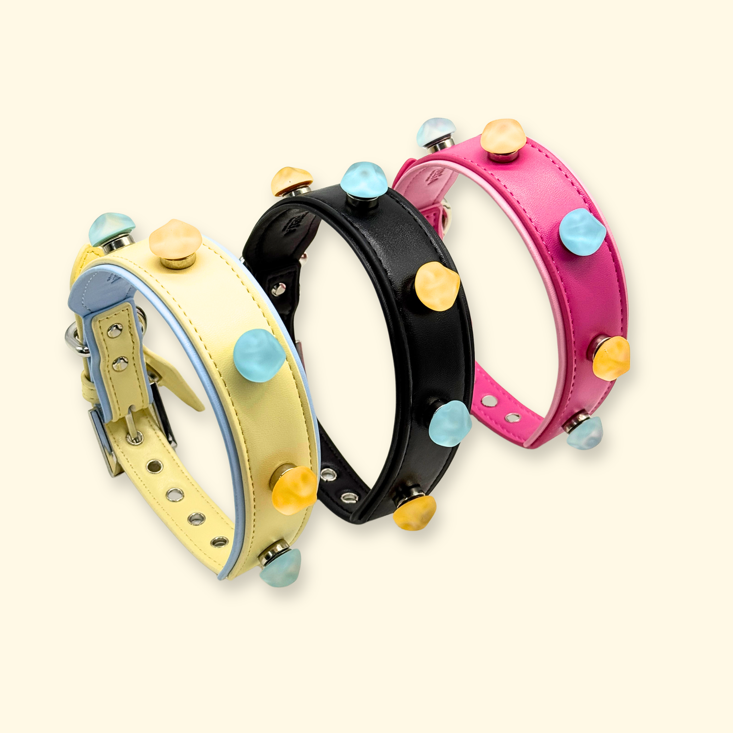 Three interchangeable snap-on dog collars in pink, yellow, and black with colorful round charms, PETIRIA modular dog collar system for customizable pet styling