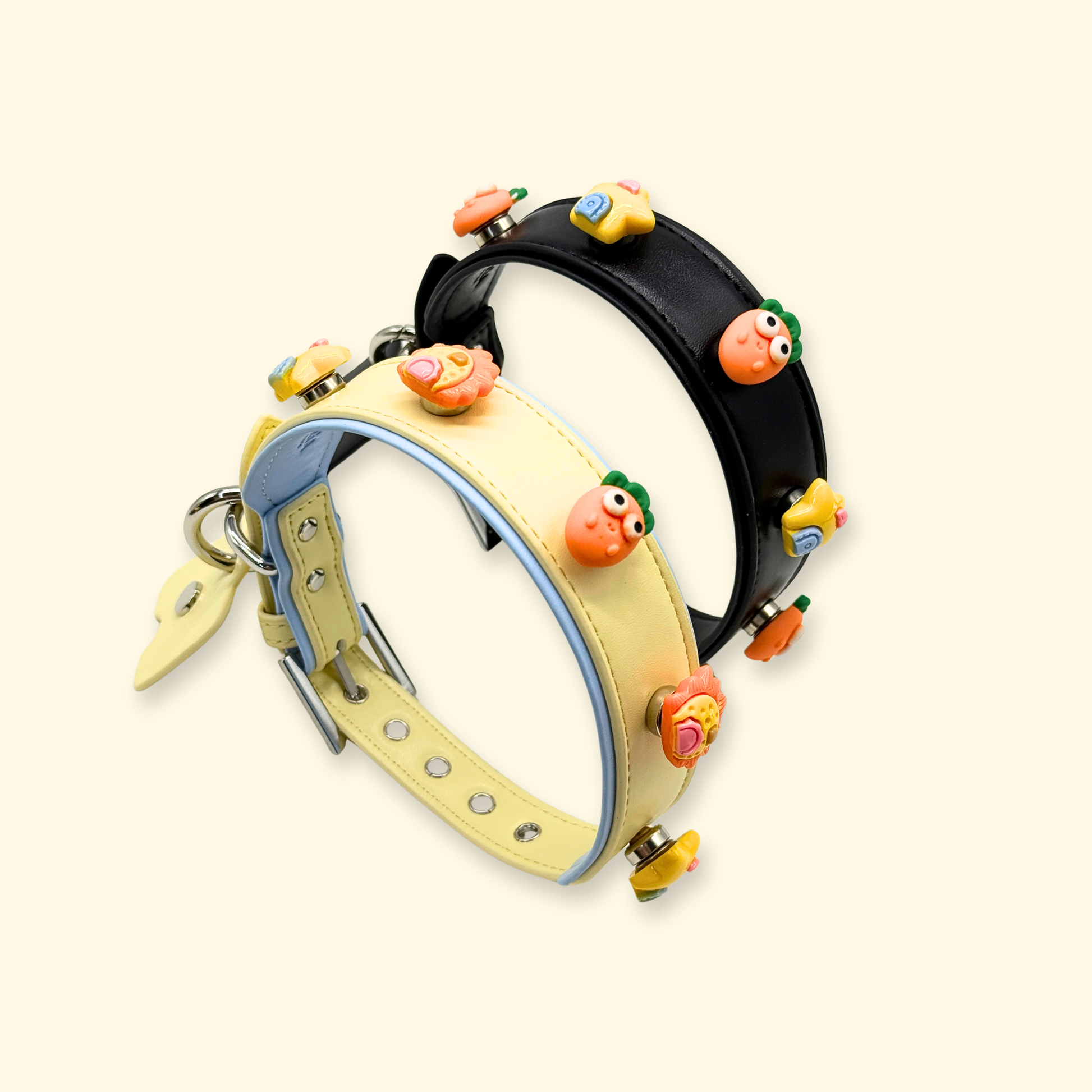 Rotated view of adjustable dog collars featuring snap-on emoji charms in carrot, sun, and star designs on black and pastel bases.