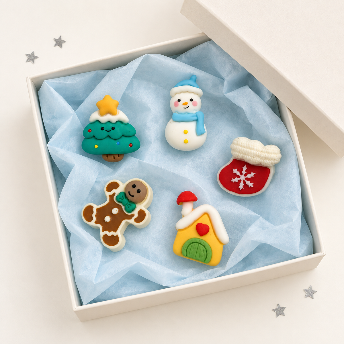 Cozy Christmas dog collar charms featuring snowman, gingerbread man, Christmas tree, mitten and little holiday house designs in a gift box