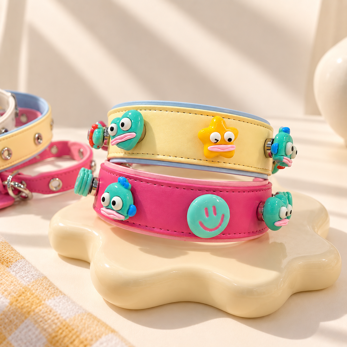 Pink and yellow Petiria dog collars styled with colorful fish, star and smiley face charms