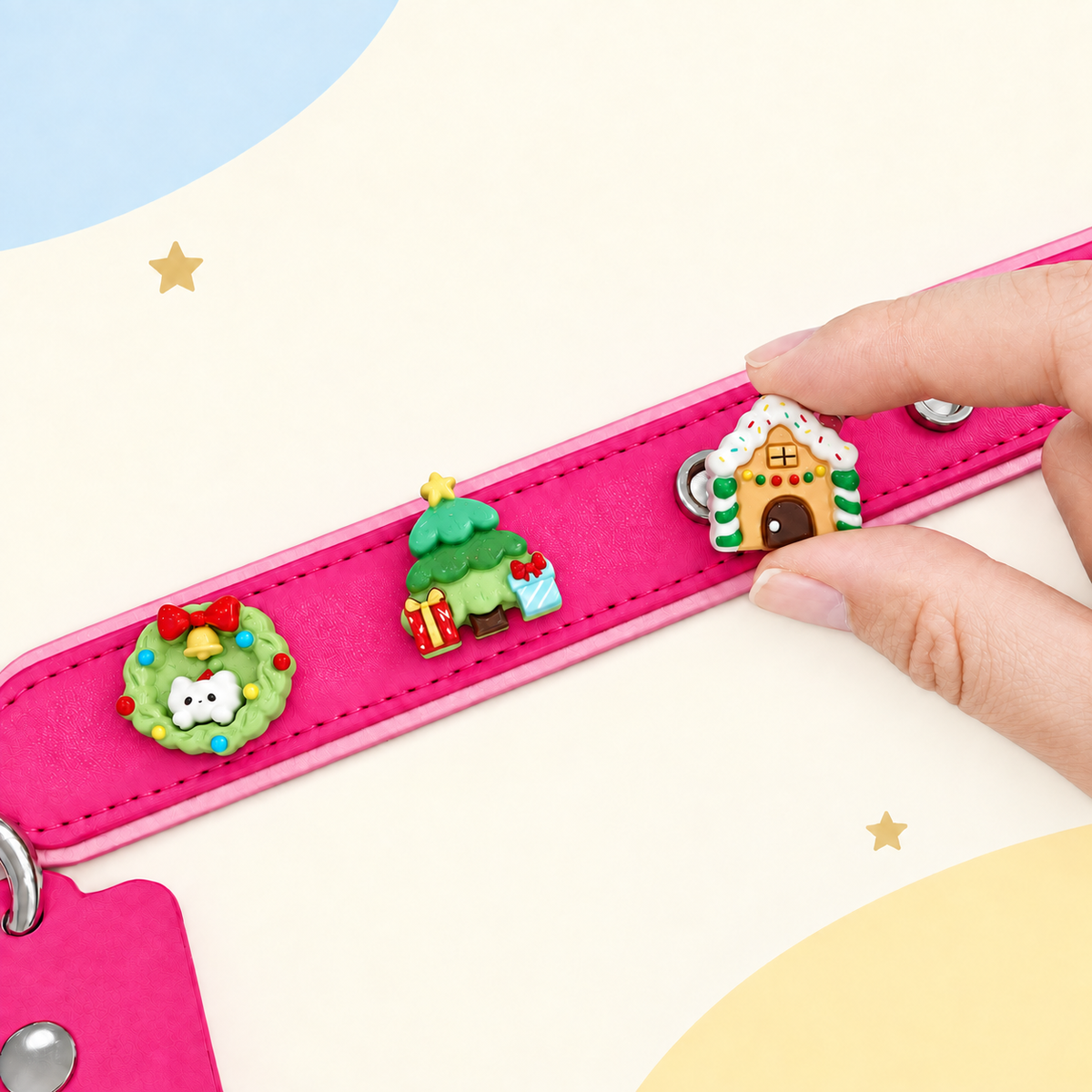 Christmas dog collar charms being snapped onto a pink Petiria interchangeable charm collar for festive holiday styling