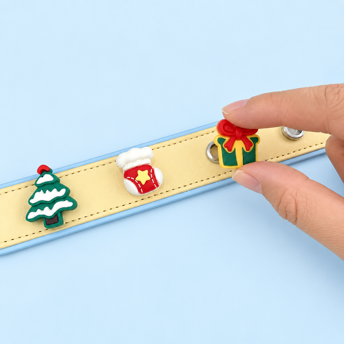 Christmas dog collar charms being snapped onto a Petiria interchangeable charm collar