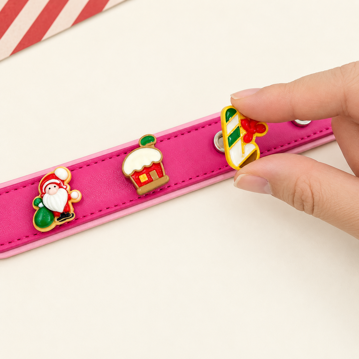 Christmas dog collar charm being snapped onto a pink Petiria interchangeable charm collar for festive holiday styling