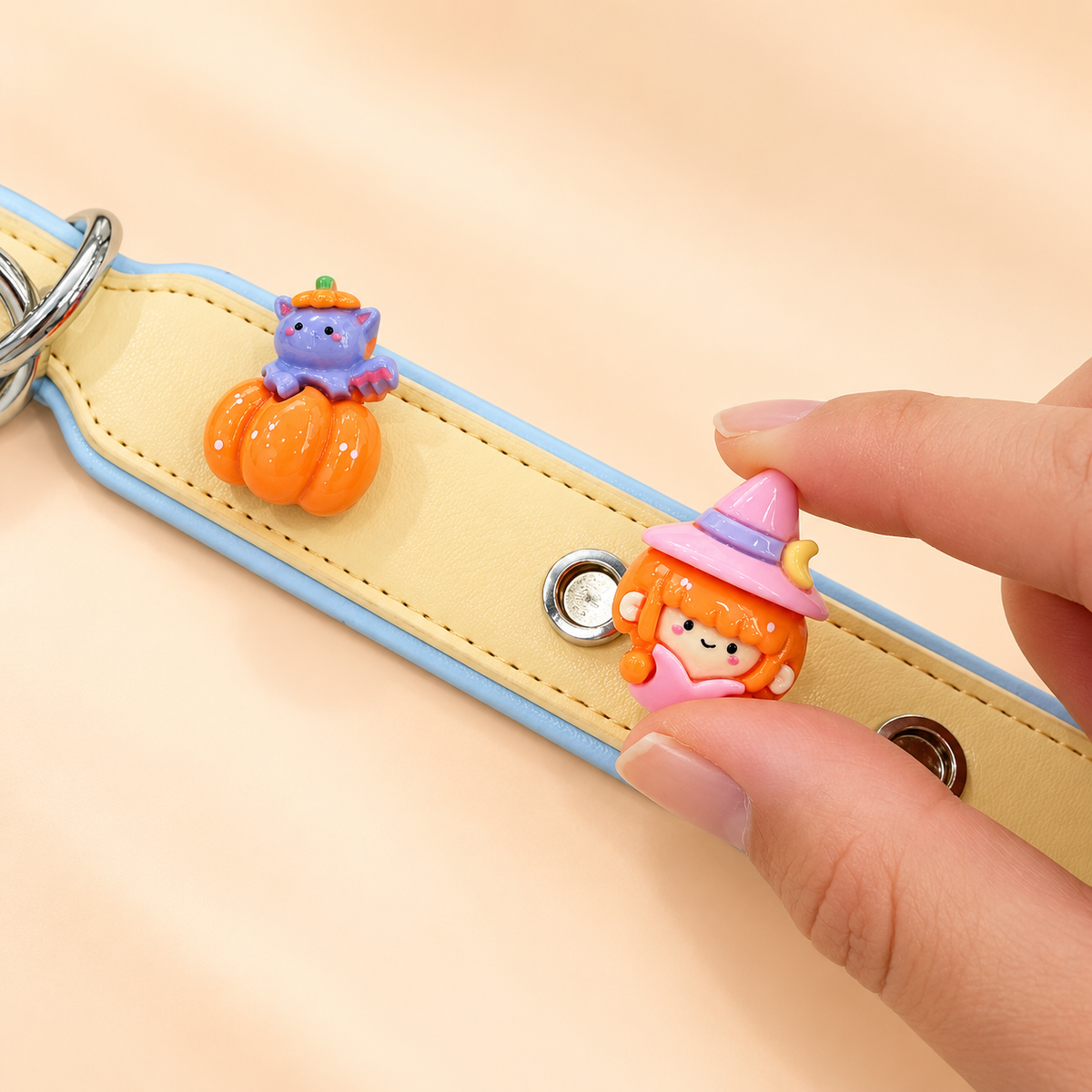Little witch dog collar charm being snapped onto a Petiria interchangeable charm collar for Halloween