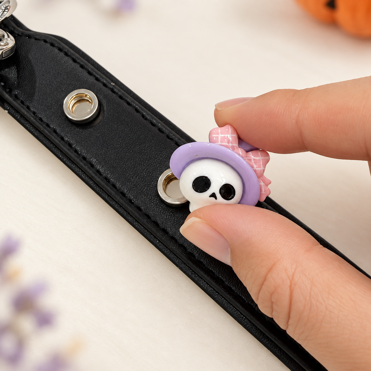 Witch hat skull dog collar charm being snapped onto a black Petiria interchangeable charm collar