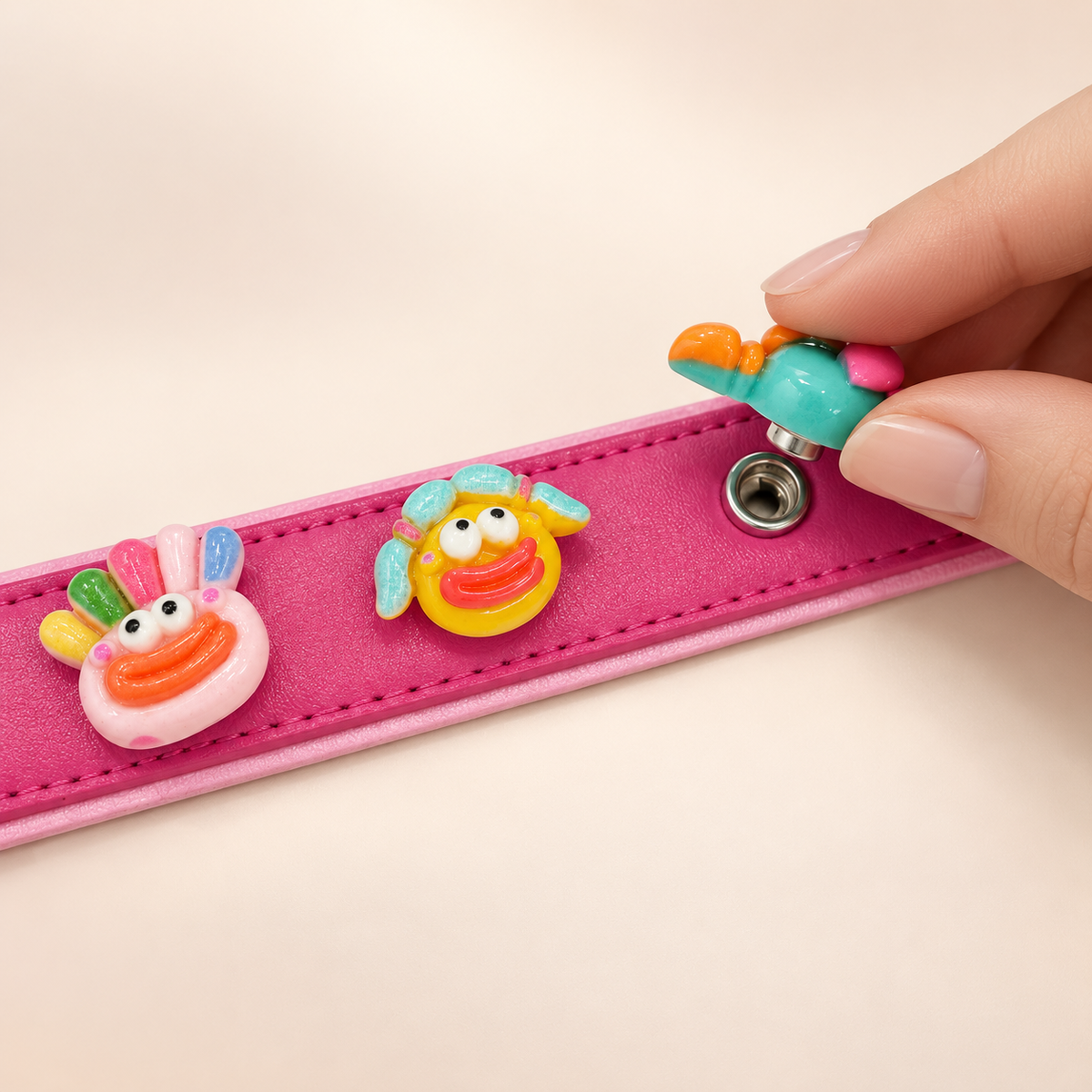 Cute monster dog collar charm being snapped onto a pink Petiria interchangeable charm collar