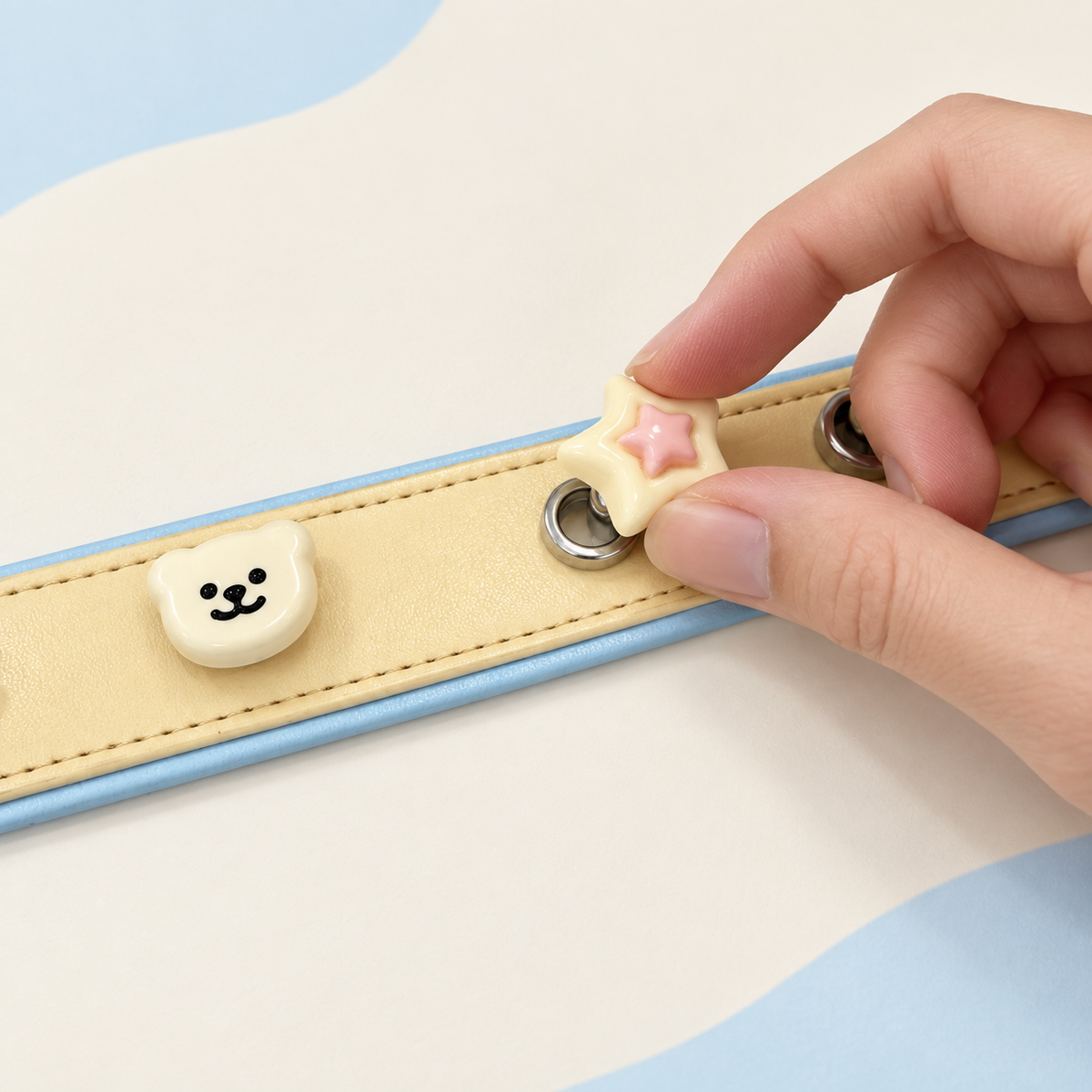 Pastel star dog collar charm being snapped onto a cream Petiria interchangeable charm collar
