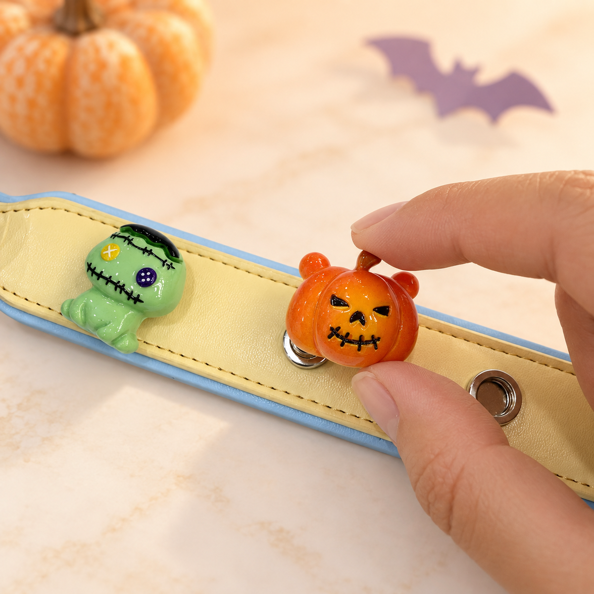 Spooky pumpkin dog collar charm being snapped onto a Petiria interchangeable charm collar for Halloween