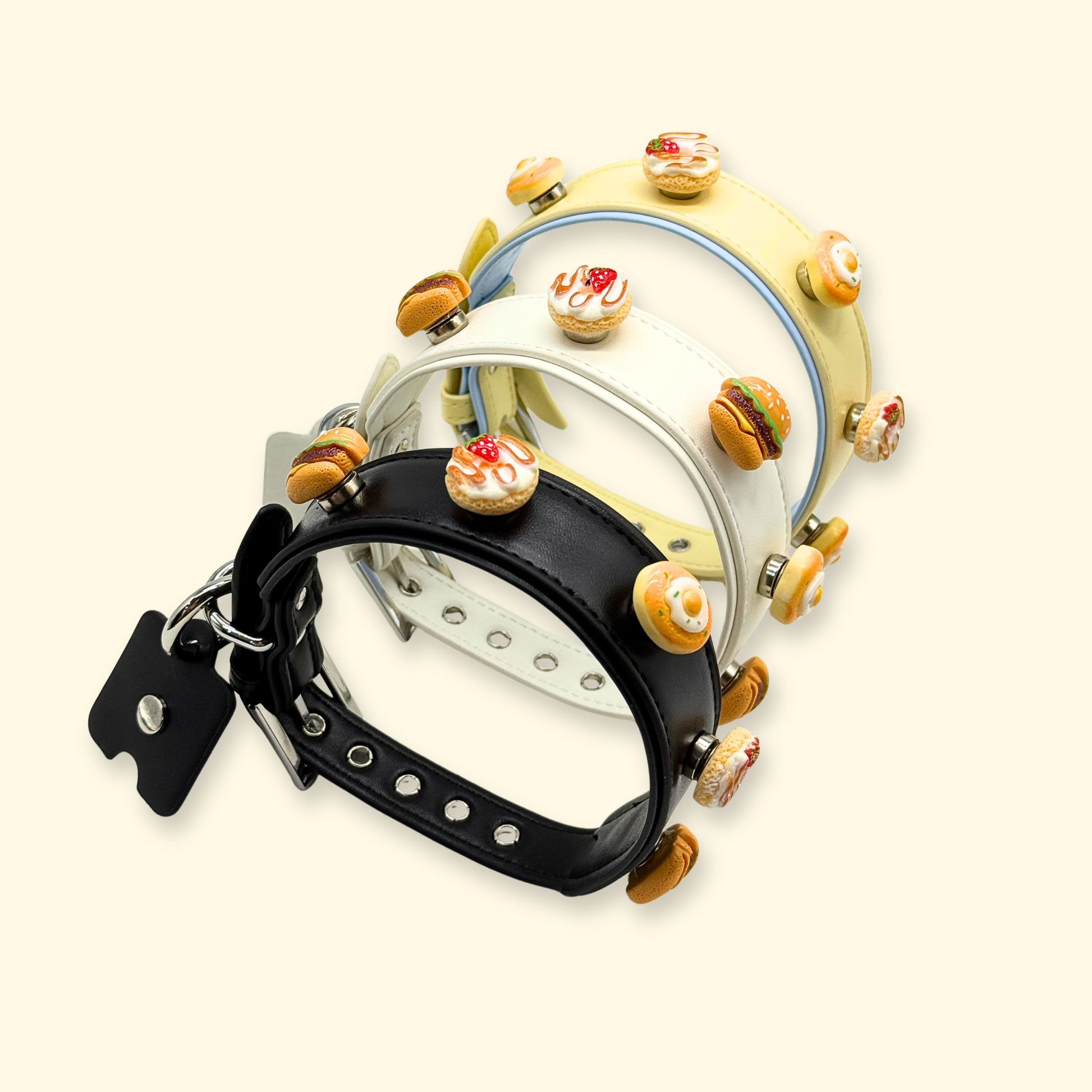 Set of food themed snap-on dog collar charms displayed on multiple interchangeable pet collars, including burger, donut, fried egg, and dessert charms, designed for customizable dog accessories in the US pet market.