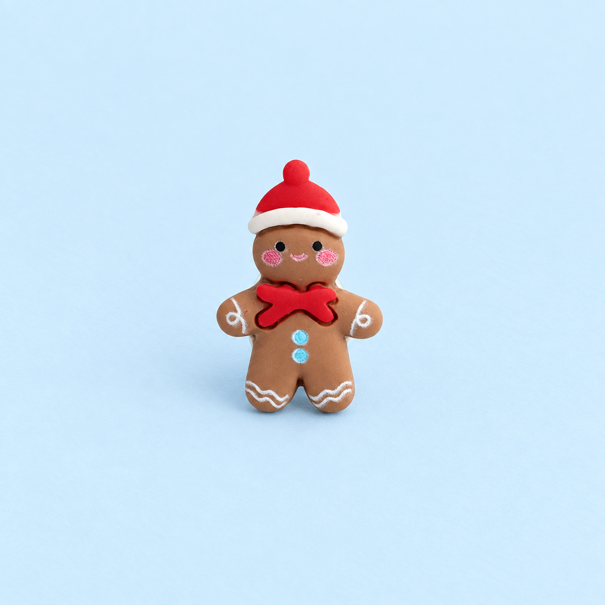 Gingerbread man dog collar charm wearing a red Santa hat and bow for festive Christmas styling