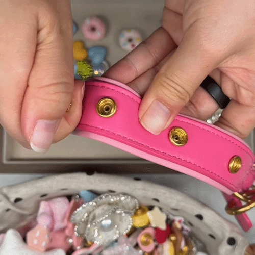 demonstration of interchangeable snap-on charms being attached to a pink dog collar