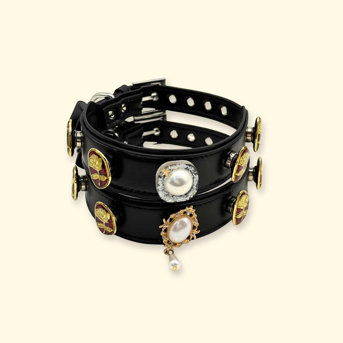 Black leather dog collar displayed with multiple interchangeable snap-on charms including pearl and rose designs, showing a customizable pet collar styling system.