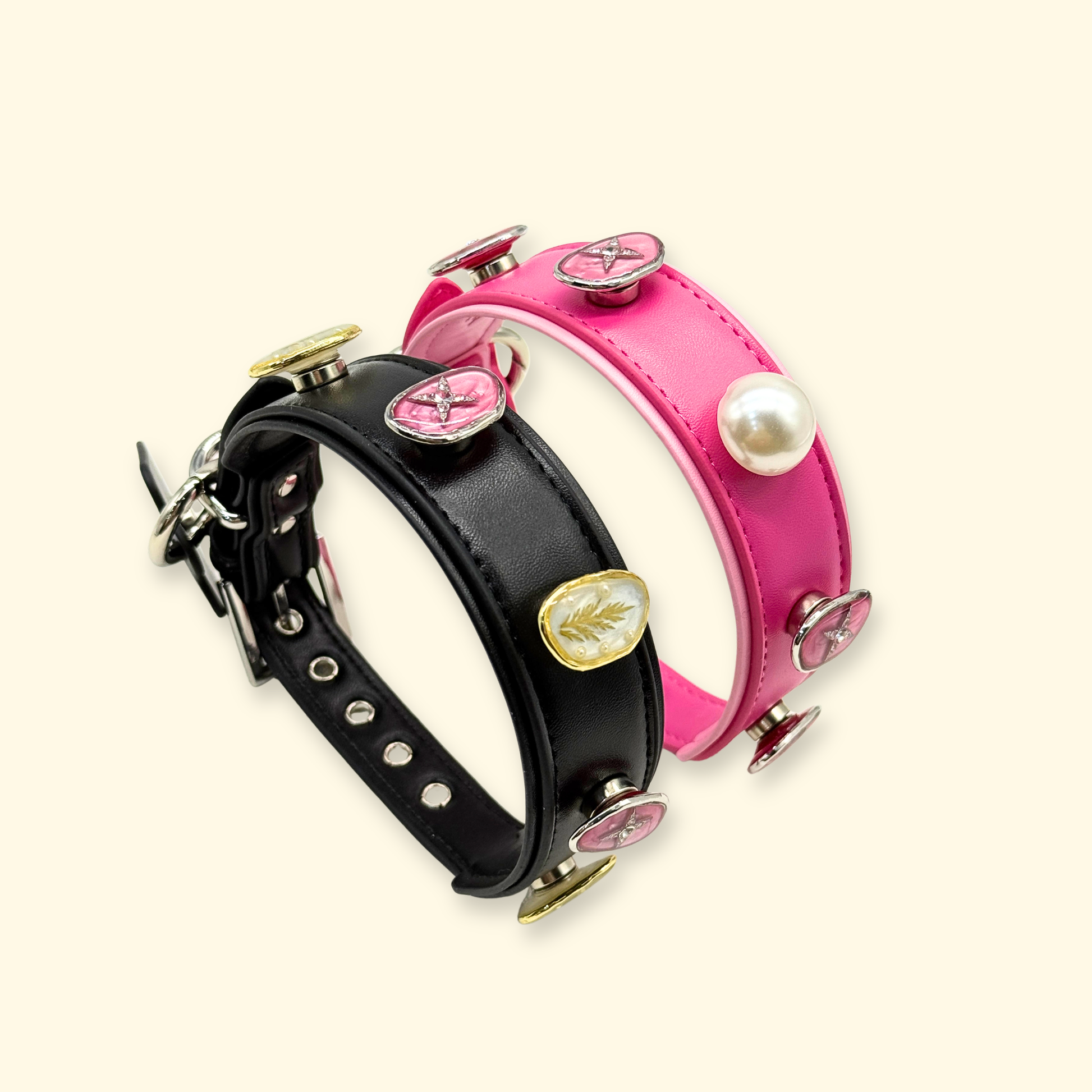 Two interchangeable dog collars in black and pink featuring multiple snap-on charms including pearl and star designs, displayed as a customizable pet accessory set for stylish dogs.