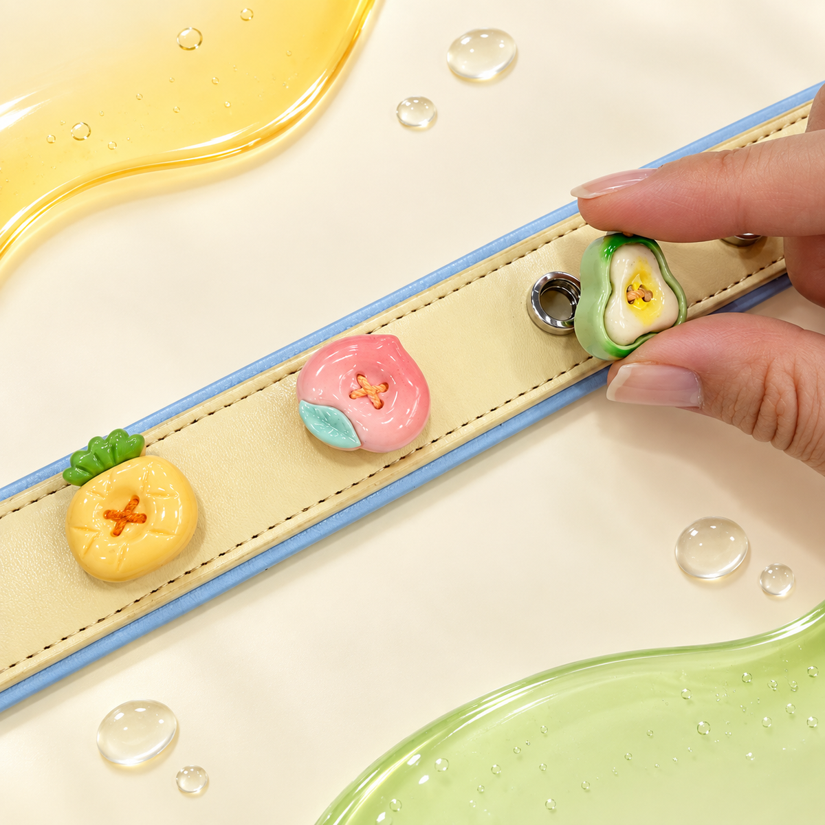 Hand styling interchangeable fruit dog collar charms on a yellow PETIRIA collar