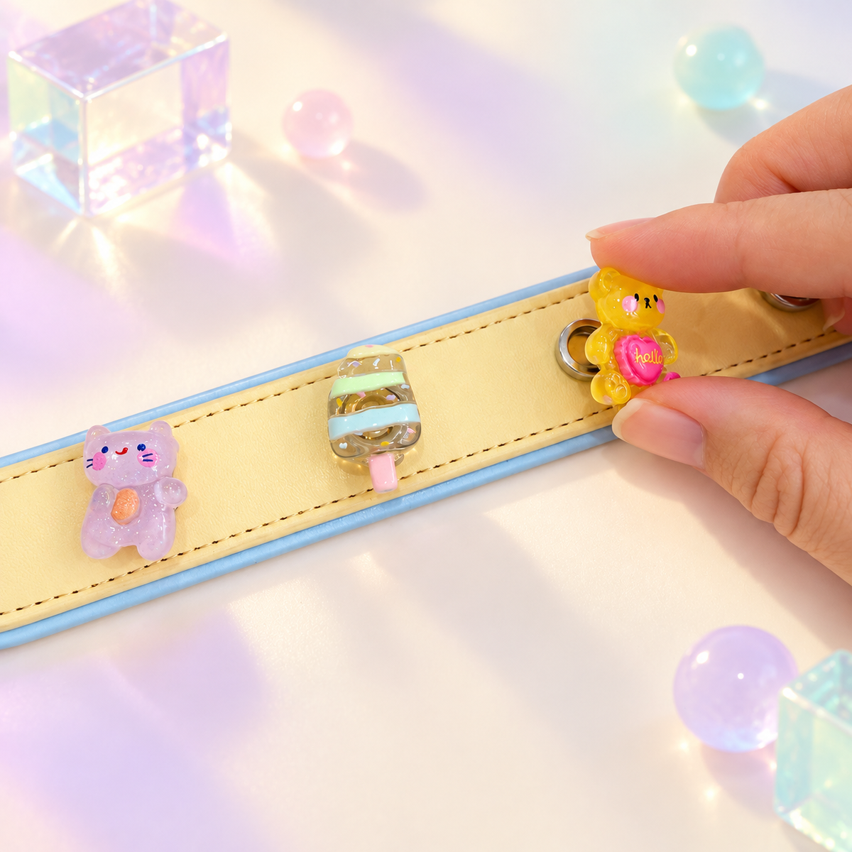 Hand styling interchangeable kawaii dog collar charms on a yellow PETIRIA collar