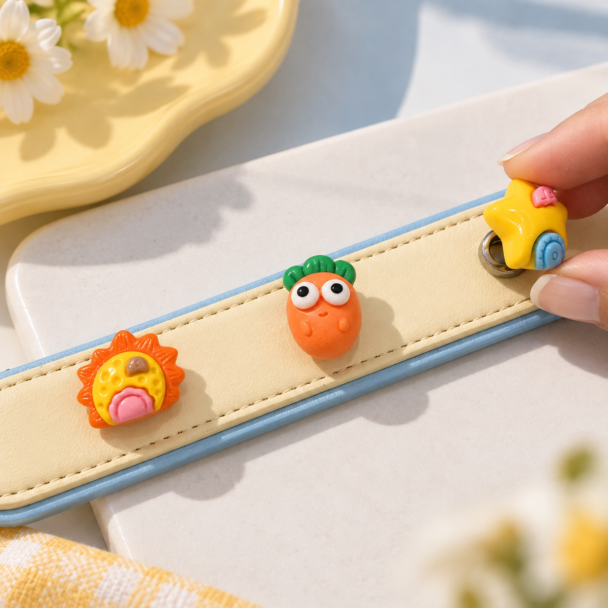 Hand styling interchangeable playful dog collar charms on a yellow PETIRIA collar