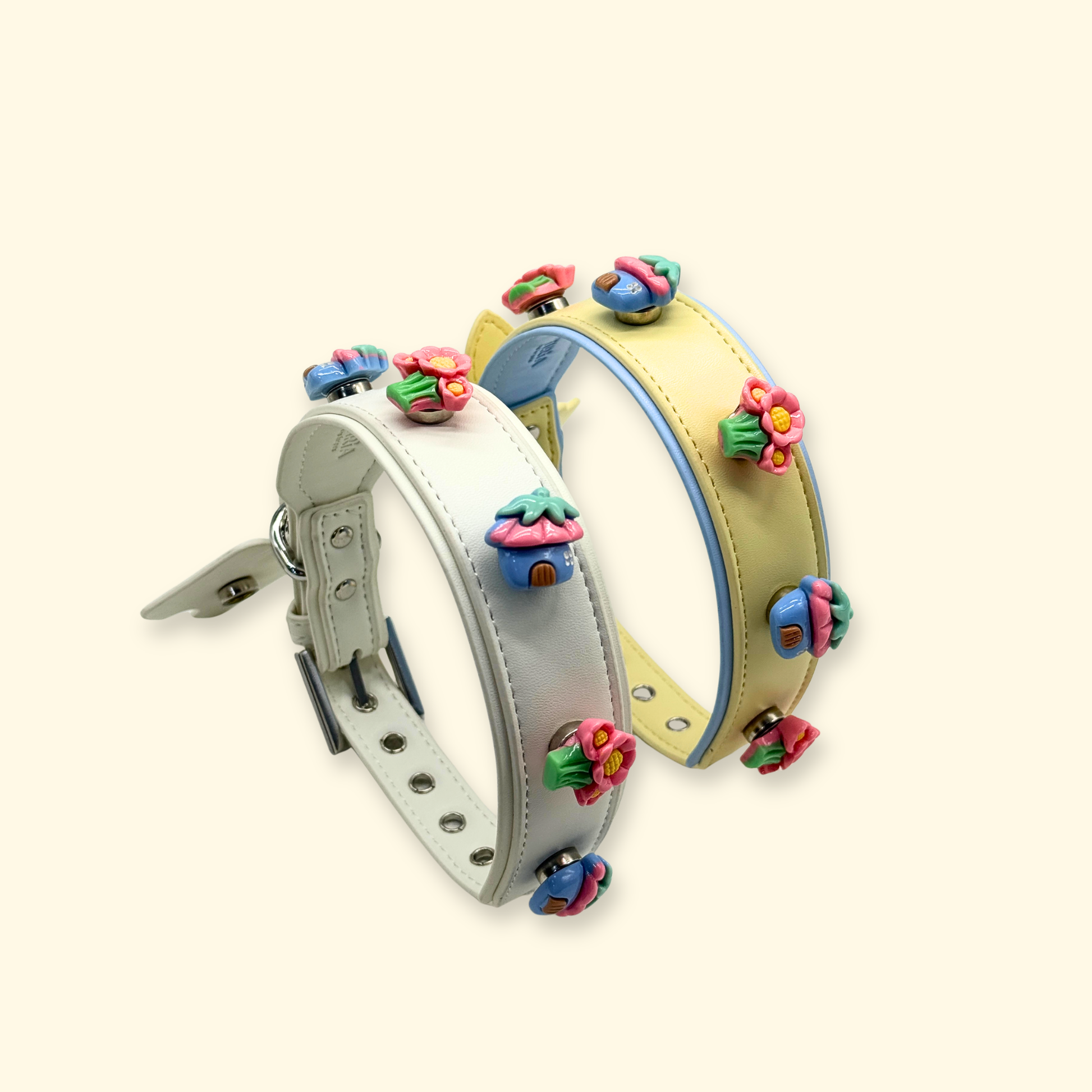 Two interchangeable dog collars in soft grey and pastel yellow with colorful flower snap-on charms, pet accessory product display
