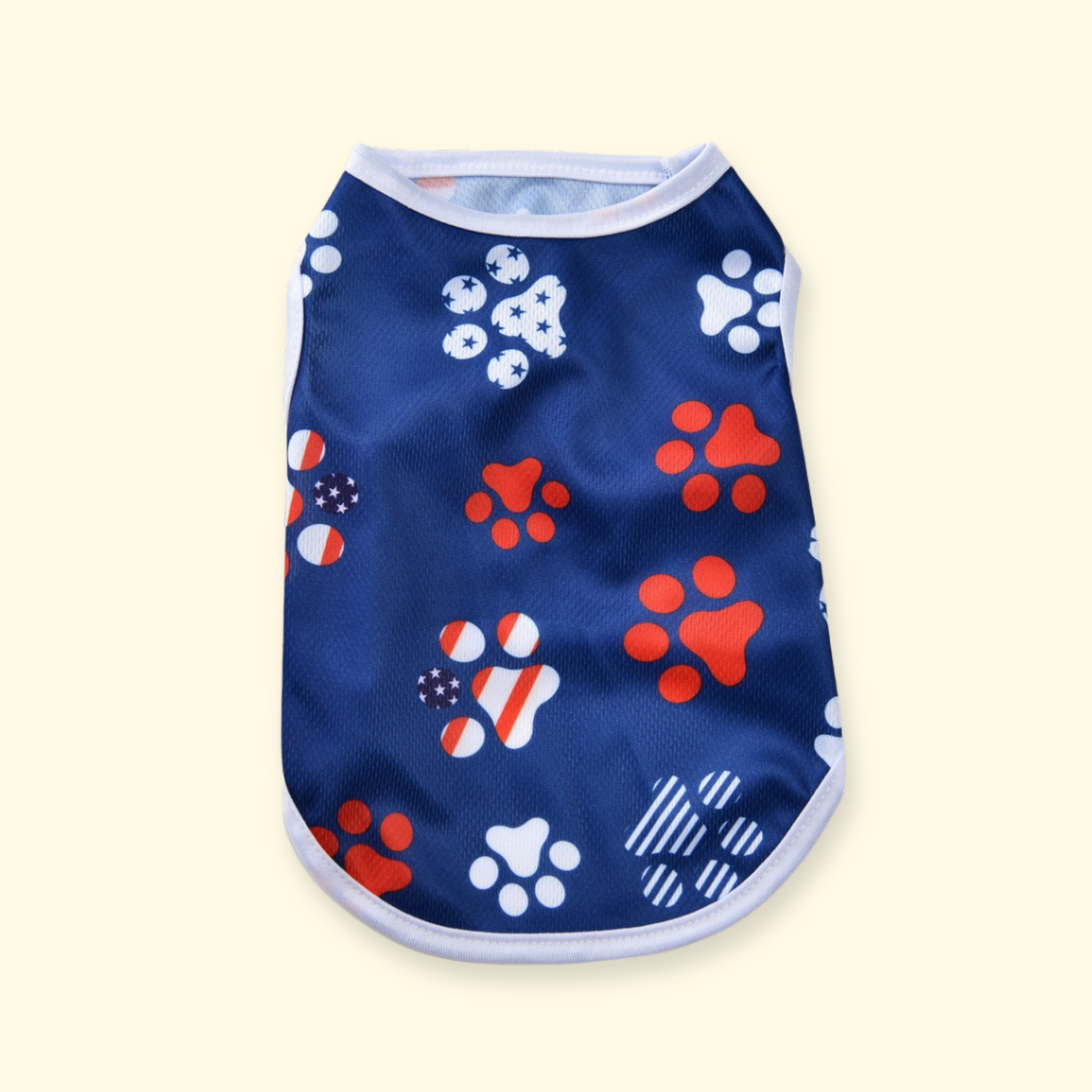 Breathable summer dog tank with patriotic paw print pattern in red, white and blue, designed for warm weather comfort.