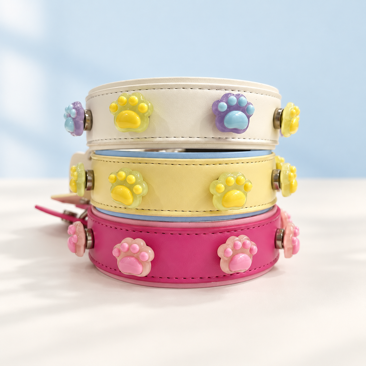 Paw print dog collar charms styled on cream, yellow and pink Petiria interchangeable collars