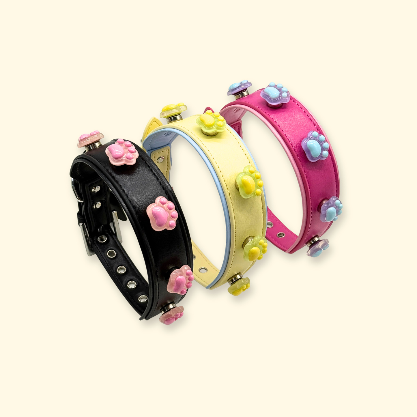Stacked interchangeable dog collars with colorful paw print snap-on charms, pet styling accessory collection