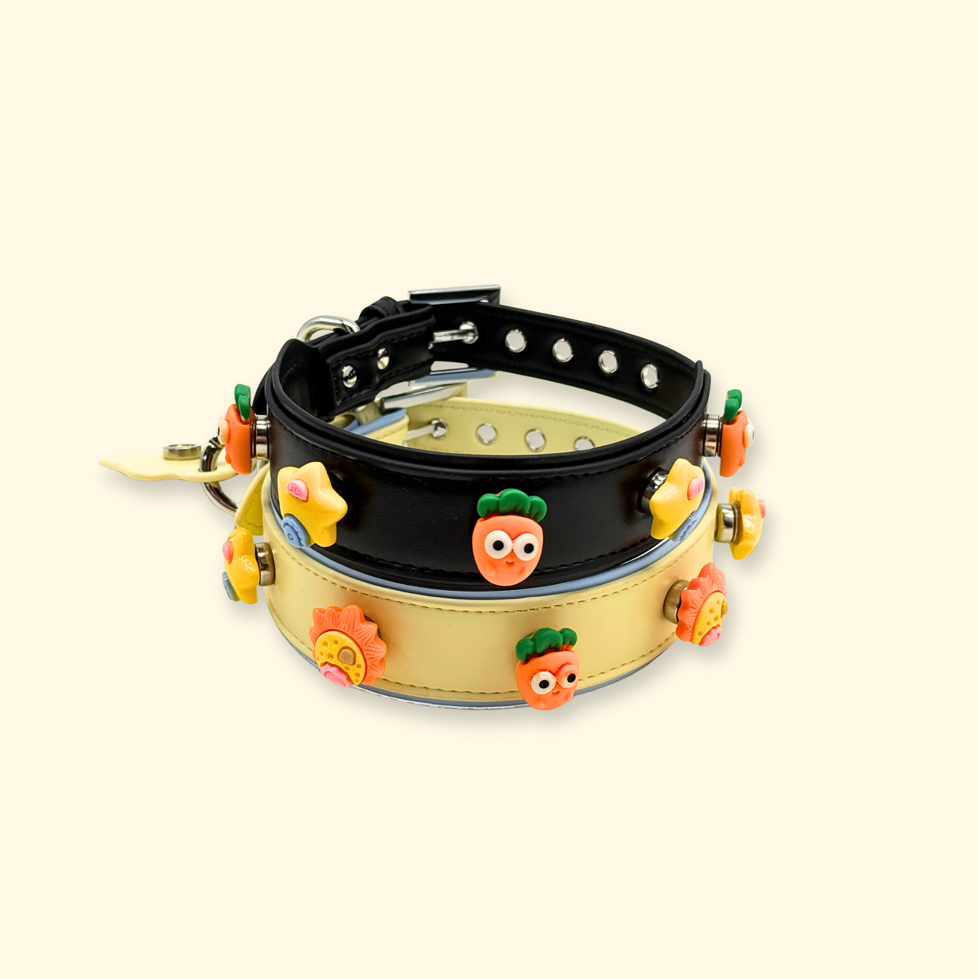 Black and yellow interchangeable dog collar with colorful emoji-style charms including star and carrot designs, styled for a playful pet accessories collection.
