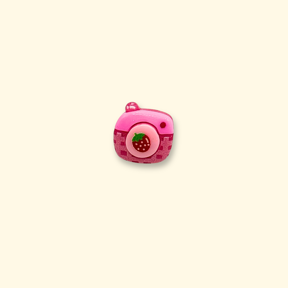 Pink camera dog collar charm with a round lens and strawberry-inspired details