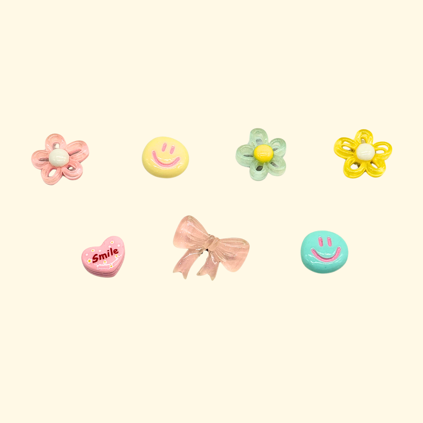 Assorted pet collar charms featuring smiley faces and colorful flowers in pastel shades