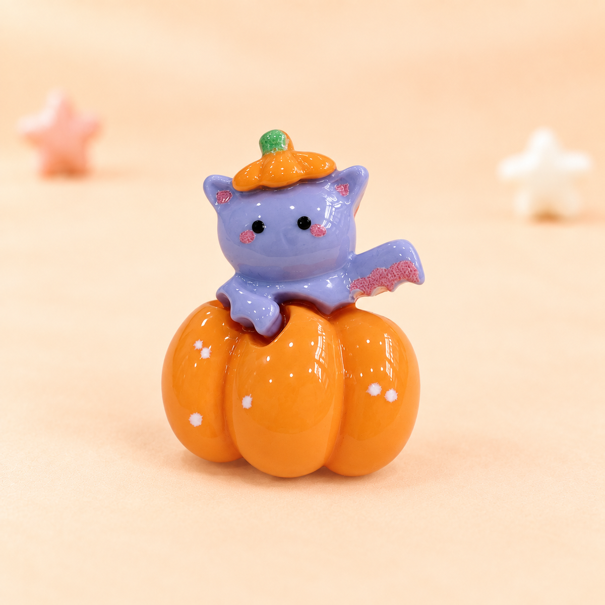 Cute purple bat dog collar charm sitting on an orange pumpkin for Halloween