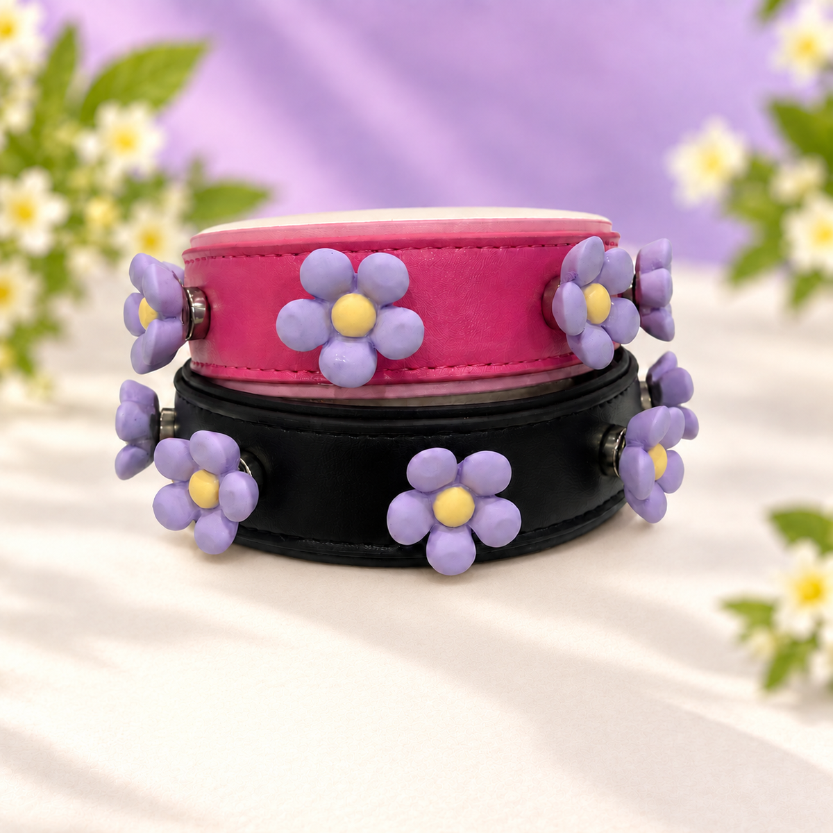 Purple daisy dog collar charms styled on pink and black PETIRIA collars