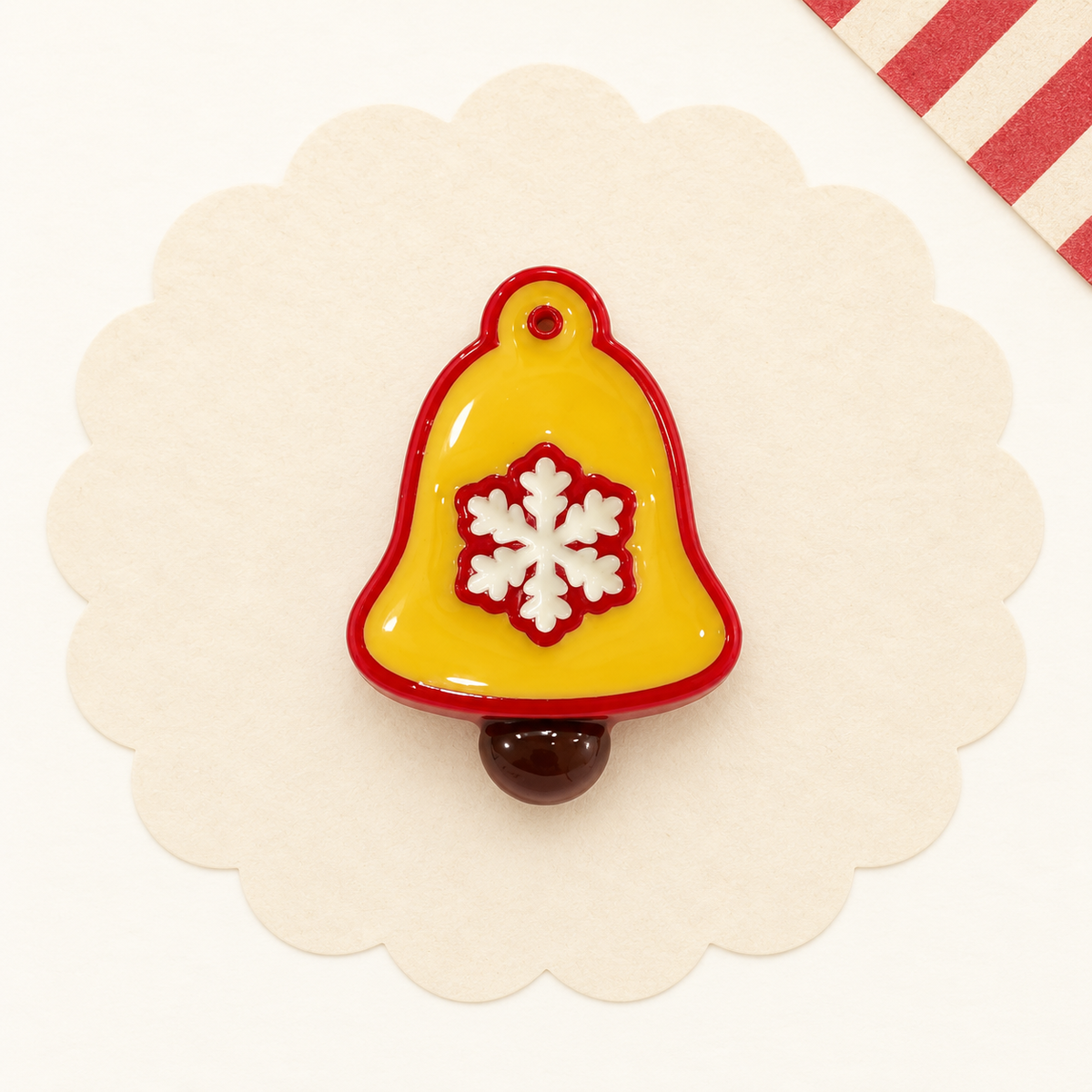 Yellow Christmas bell dog collar charm with a white snowflake and red trim for festive holiday styling