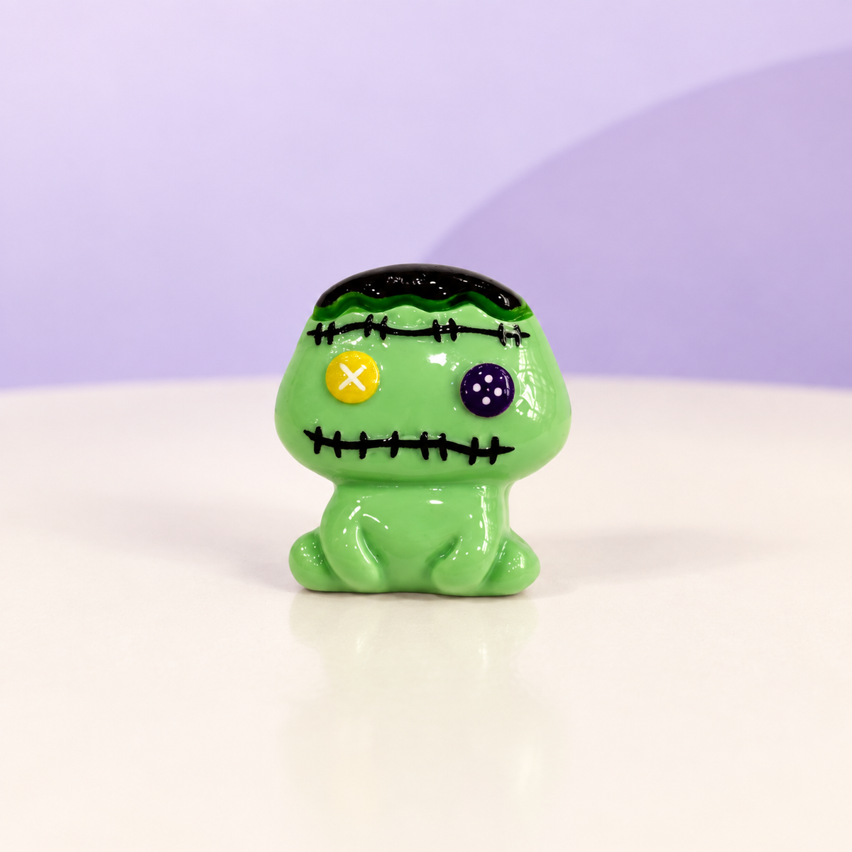Green stitched monster dog collar charm with colorful button eyes for a playful Halloween look