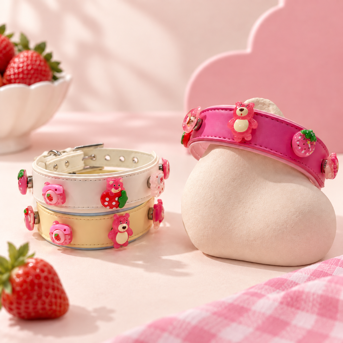 Pink and cream Petiria dog collars styled with strawberry bear and dessert-inspired charms