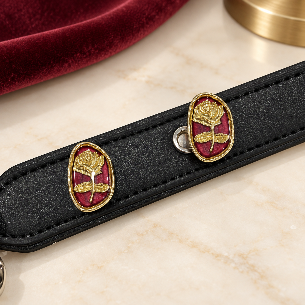 Black PETIRIA collar styled with gold-tone Vintage Rose dog collar charms on deep red backgrounds