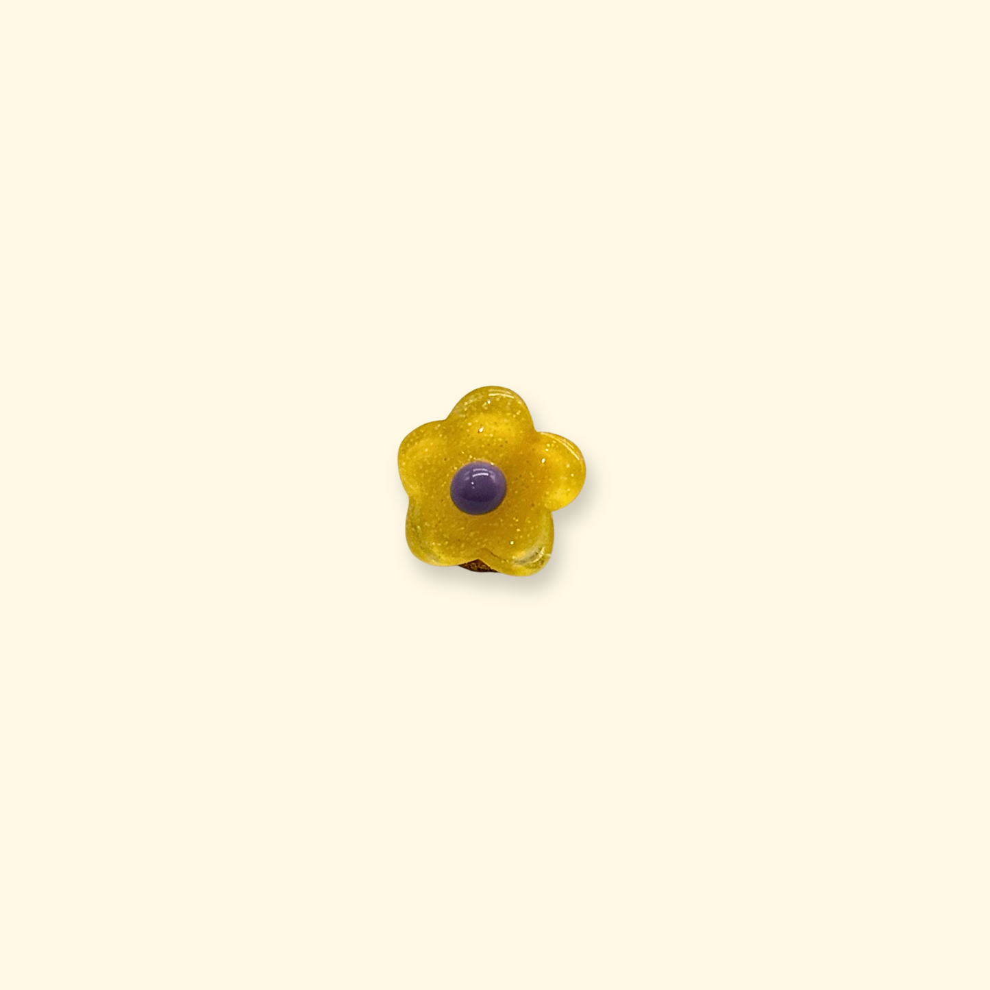 A small yellow floral snap-on charm with a purple center, designed for decorating dog collars with interchangeable pet accessories.