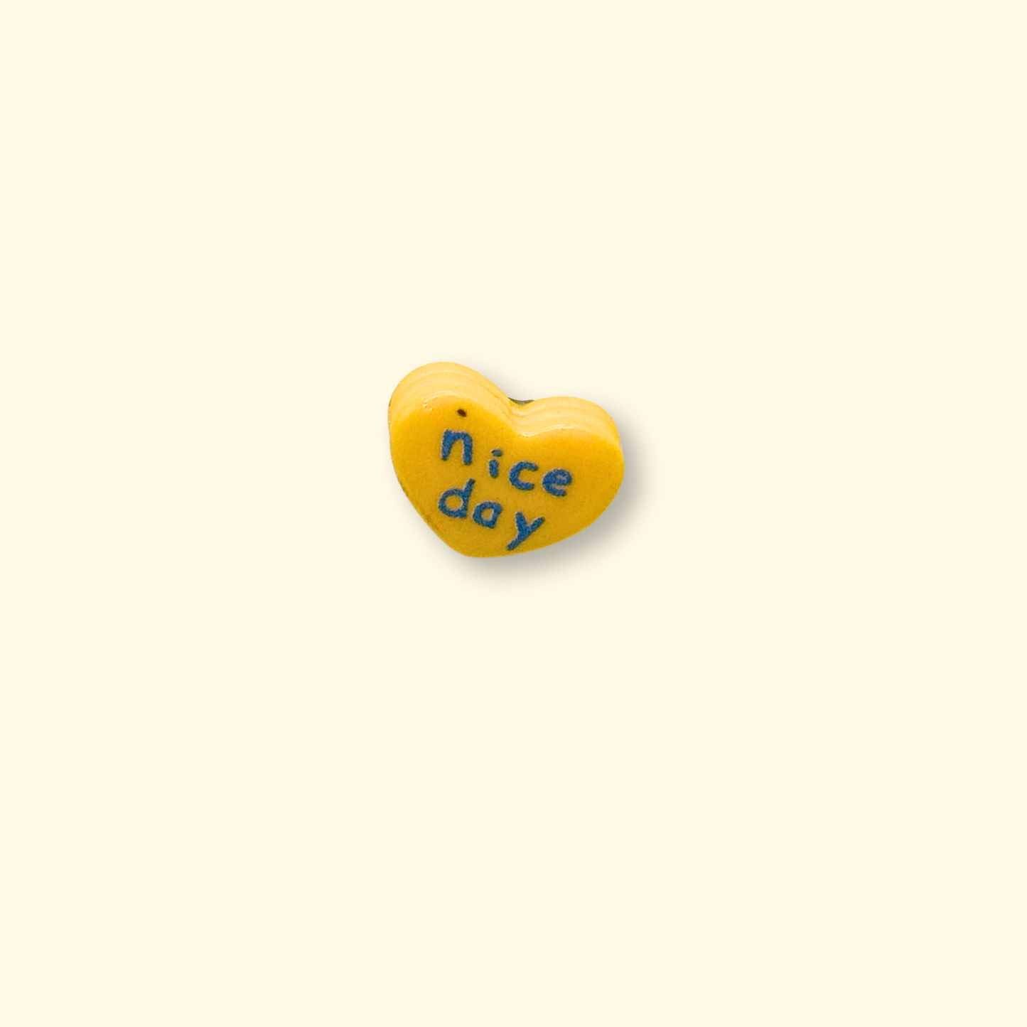 Bright yellow heart charm for pet collars with "nice day" text, a cheerful accessory for dogs and cats
