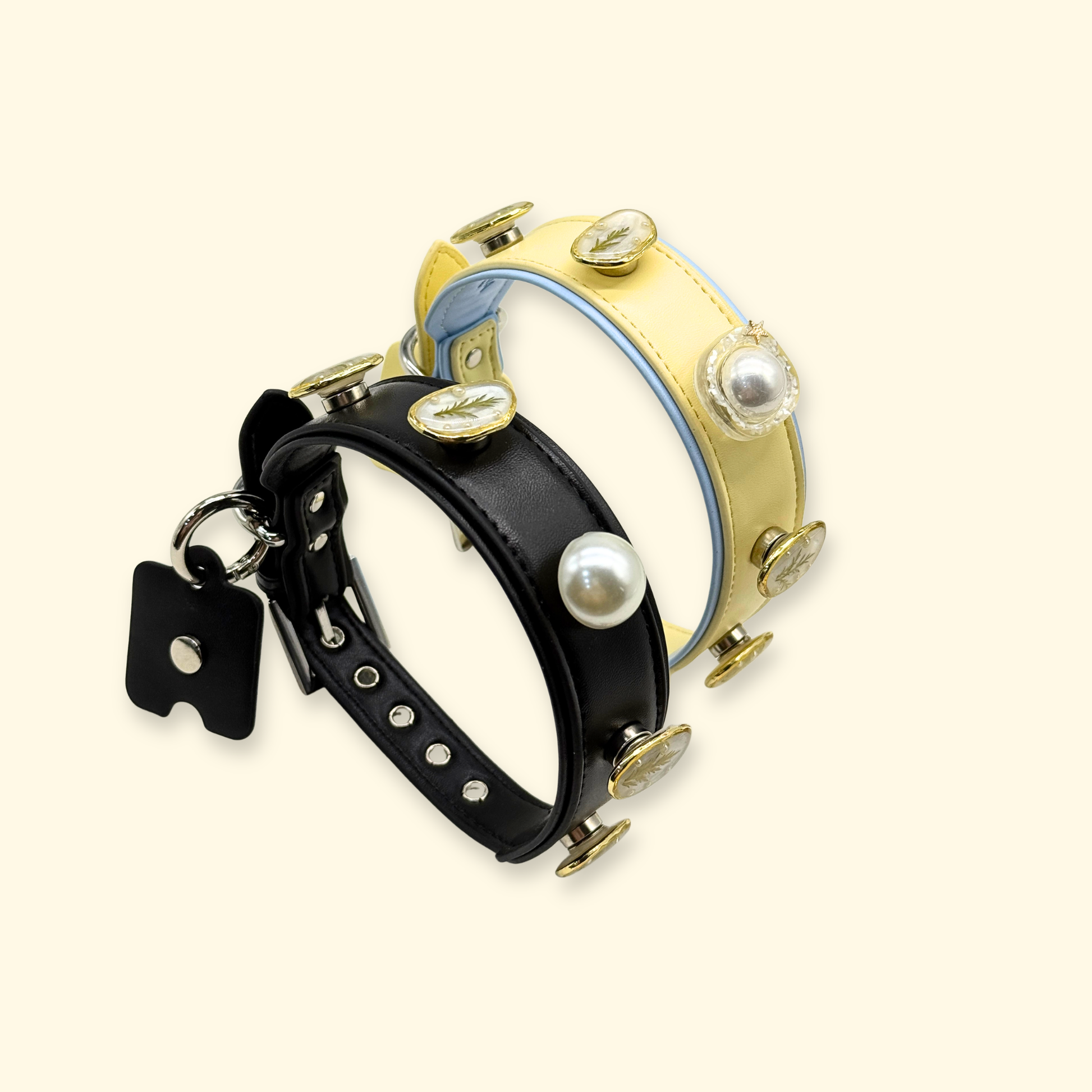 Yellow and black dog collars displaying interchangeable snap-on charm system with leaf and pearl accessories for pet styling